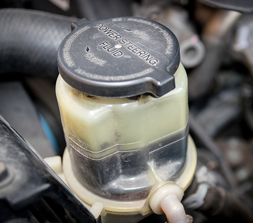 Power steering fluid reservoir under a vehicle&rsquo;s hood.