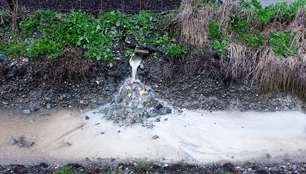 Stormwater runoff flowing from a pipe into a small stream