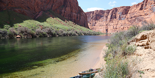 Kayaks resting along the Colorado River inside the Grand Canyon.